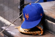 A New York Mets cap and glove sits in the dugout during a baseball game against the Miami Marlins, Thursday, Aug. 5, 2021, in Miami. (AP Photo/Lynne Sladky)