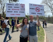 Arian Mahrer (left) and George Angelis (right) holding signs together at the rally against the reopening of Silver Lake Park Road on Saturday, April 19, 2025.