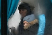 A woman and child peer out of the window of a bus as they leave Sievierodonetsk, the Luhansk region, eastern Ukraine, Thursday, Feb. 24, 2022. Russian President Vladimir Putin on Thursday announced a military operation in Ukraine and warned other countries that any attempt to interfere with the Russian action would lead to "consequences you have never seen." (AP Photo/Vadim Ghirda)